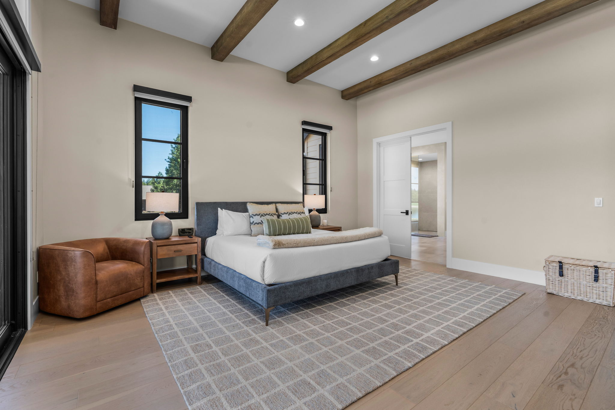 Wake up to sweeping Tanager Lake views — the primary suite features a king bed, gas fireplace, private patio access, and a spa-like ensuite with soaking tub, dual-head tiled shower, and walk-in closet.