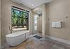 The primary suite offers a spa-like bathroom with dual vanity, soaking tub, tiled shower, and walk-in closet.