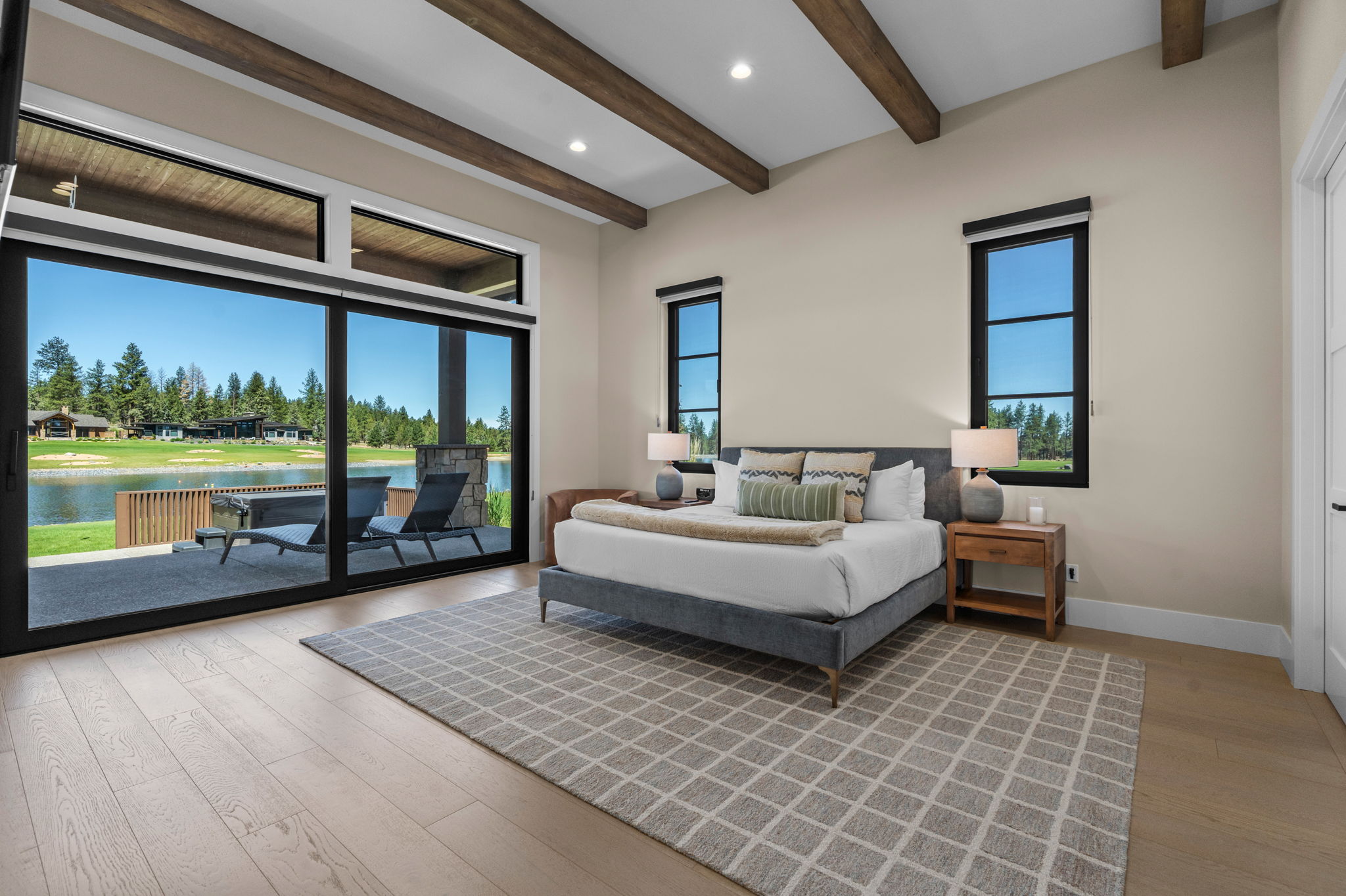 Wake up to sweeping Tanager Lake views — the primary suite features a king bed, gas fireplace, private patio access, and a spa-like ensuite with soaking tub, dual-head tiled shower, and walk-in closet.