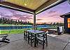 The covered outdoor patio is made for gathering — dining for 8, natural gas fire pit, private hot tub, space heater, and a natural gas BBQ, all with Tanager Lake as your backdrop.