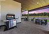 The covered outdoor patio is made for gathering — dining for 8, natural gas fire pit, private hot tub, space heater, and a natural gas BBQ, all with Tanager Lake as your backdrop.
