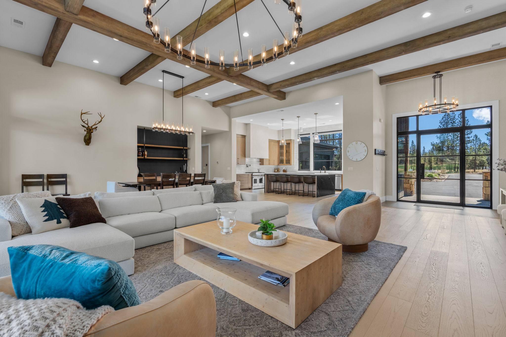 Every seat in the house has a view — the open living room offers comfortable seating for the whole group, a gas fireplace, and Tanager Lake as the backdrop.