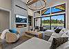 Every seat in the house has a view — the open living room offers comfortable seating for the whole group, a gas fireplace, and Tanager Lake as the backdrop.