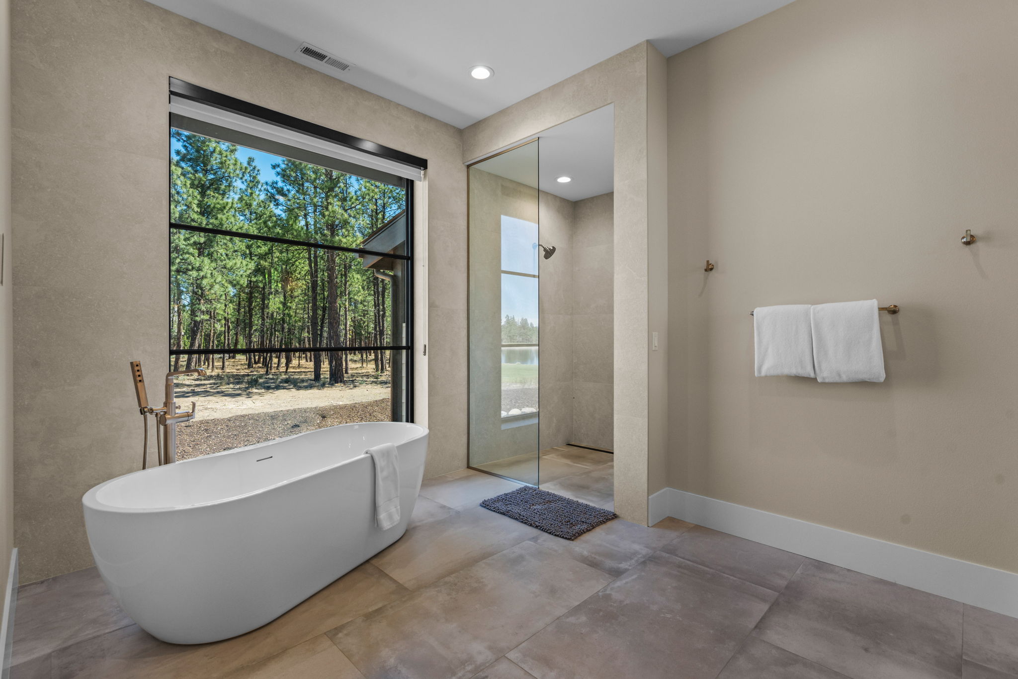 The primary suite offers a spa-like bathroom with dual vanity, soaking tub, tiled shower, and walk-in closet.