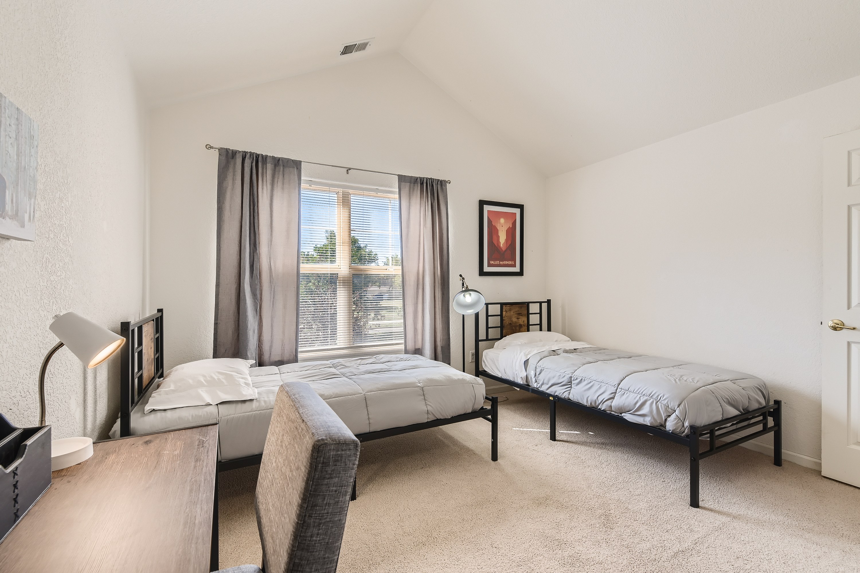 Guest bedroom featuring 2 twin beds and a desk. 