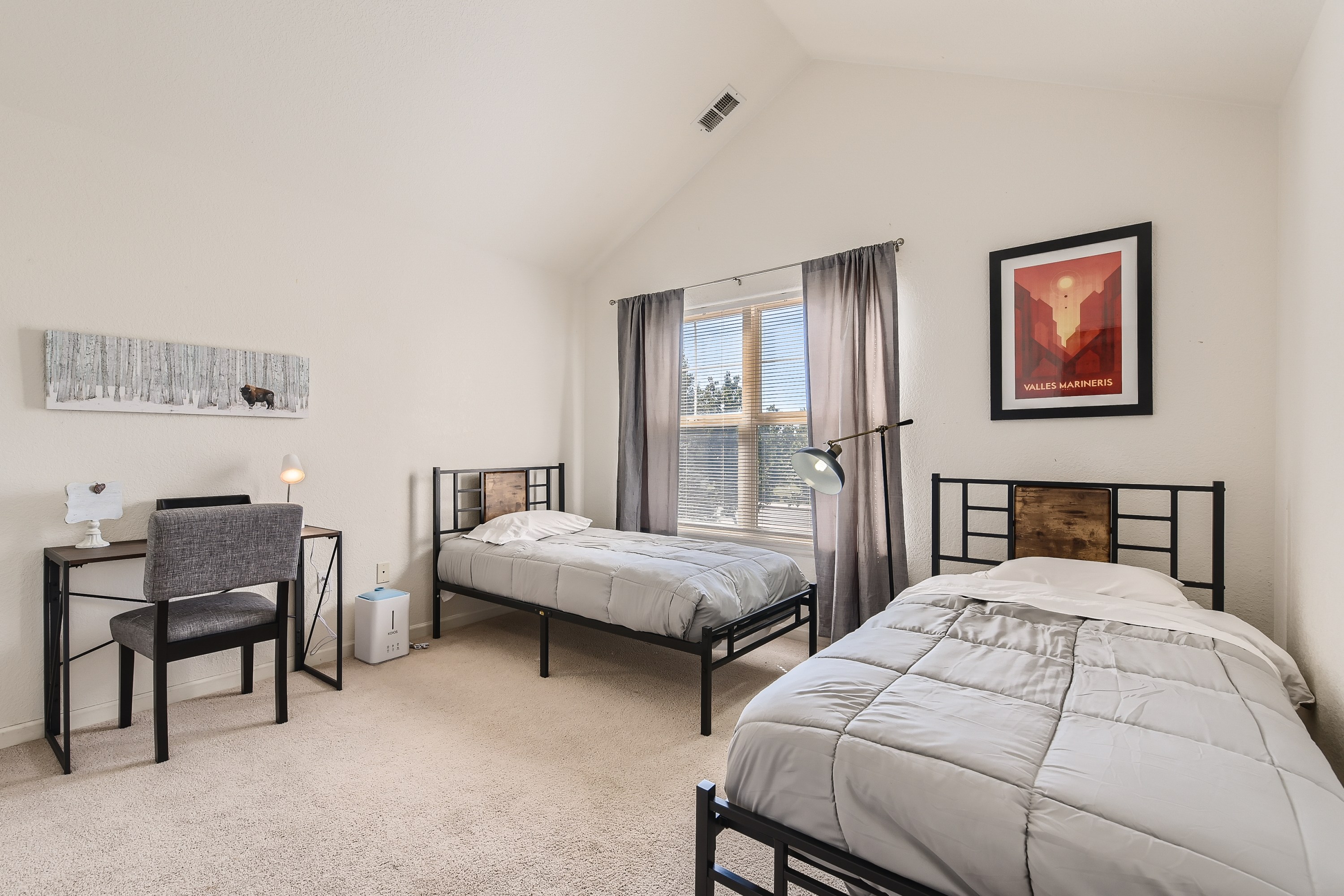 Guest bedroom featuring 2 twin beds and a desk. 