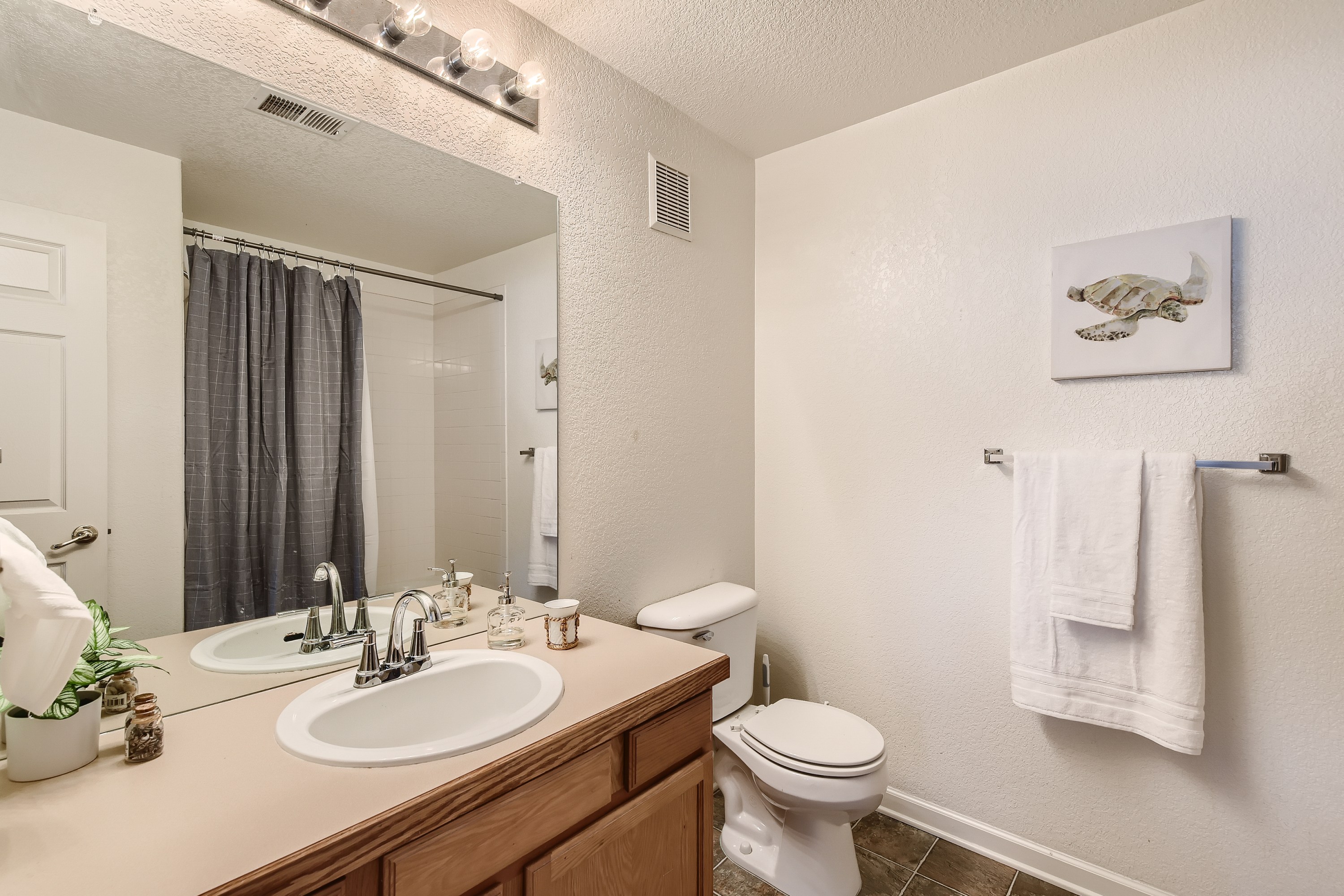 Clean and functional guest bathroom featuring a tub/shower combination.