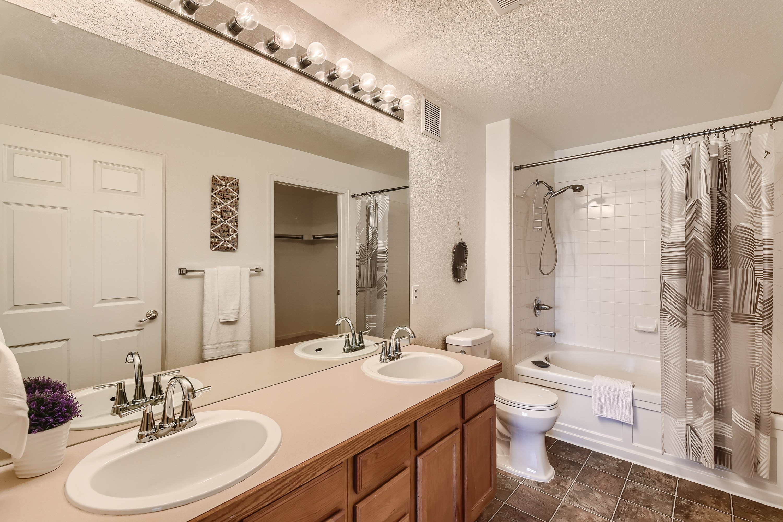Ensuite bathroom connected to the king bedroom, featuring a shower/tub combo and double vanities.