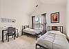 Guest bedroom featuring 2 twin beds and a desk. 
