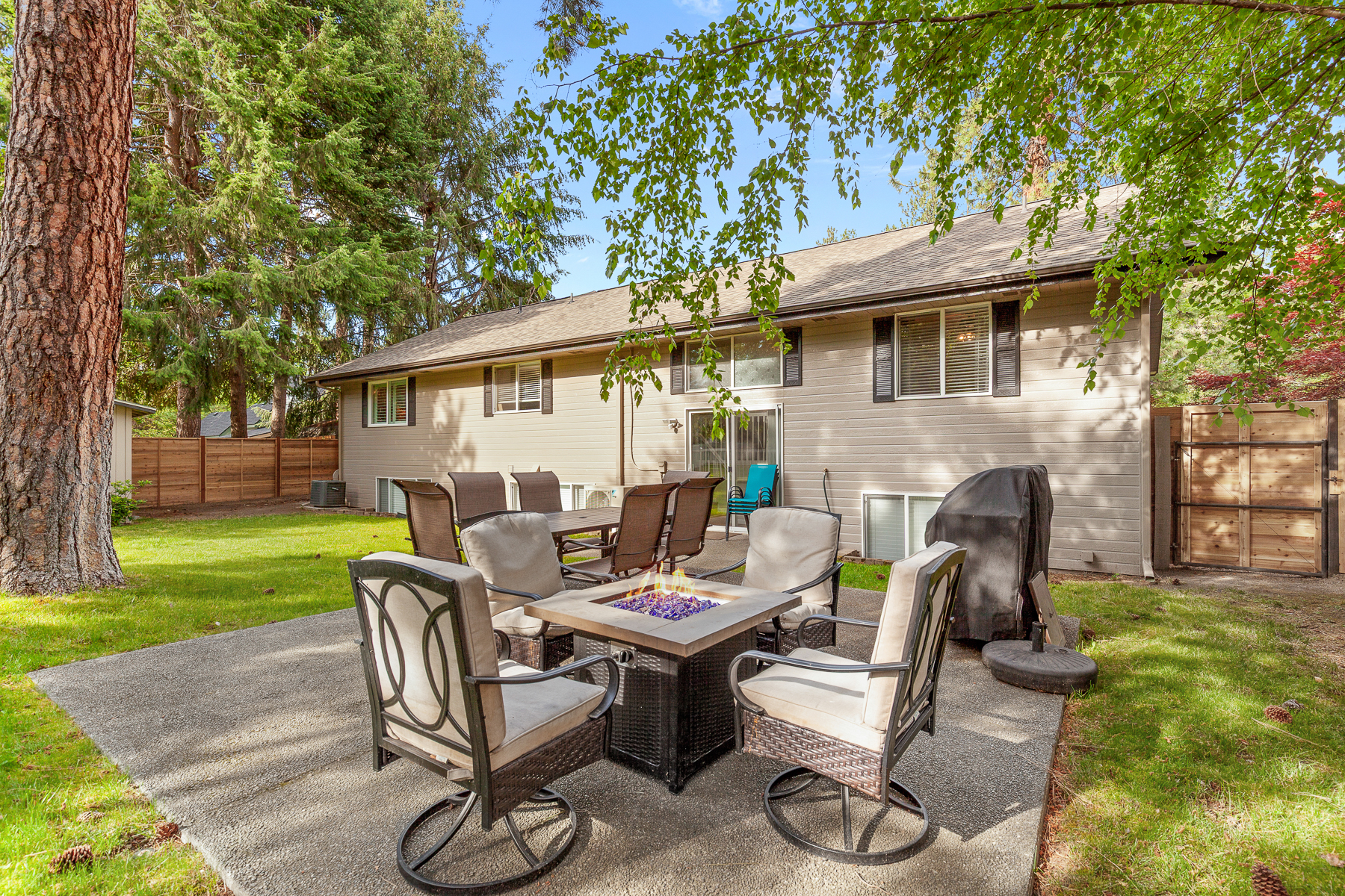 Private backyard – includes a fenced yard, fire pit table with seating for six, and a grill.