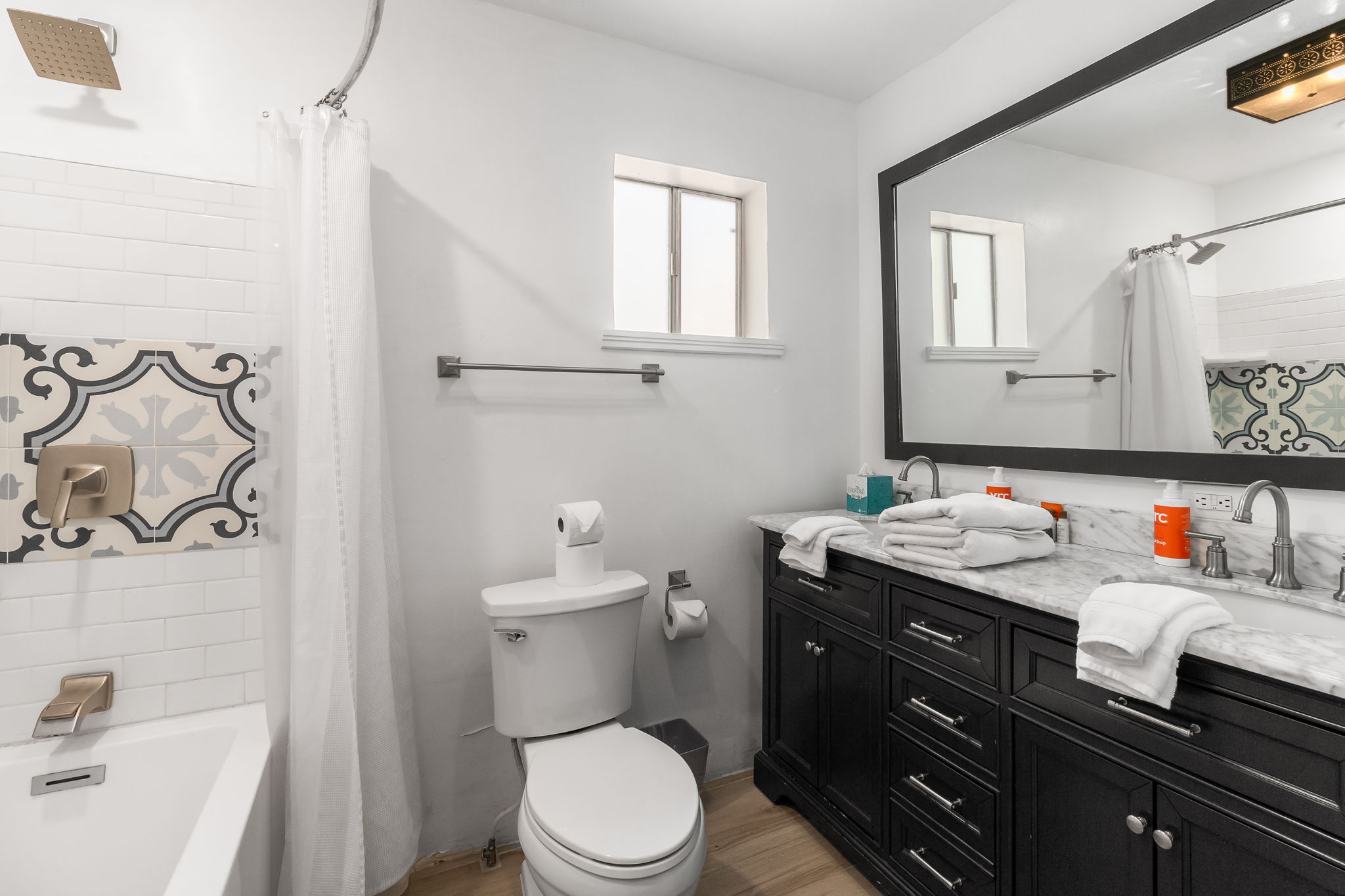 Full bathroom with convenient tub/shower combo and modern finishes.