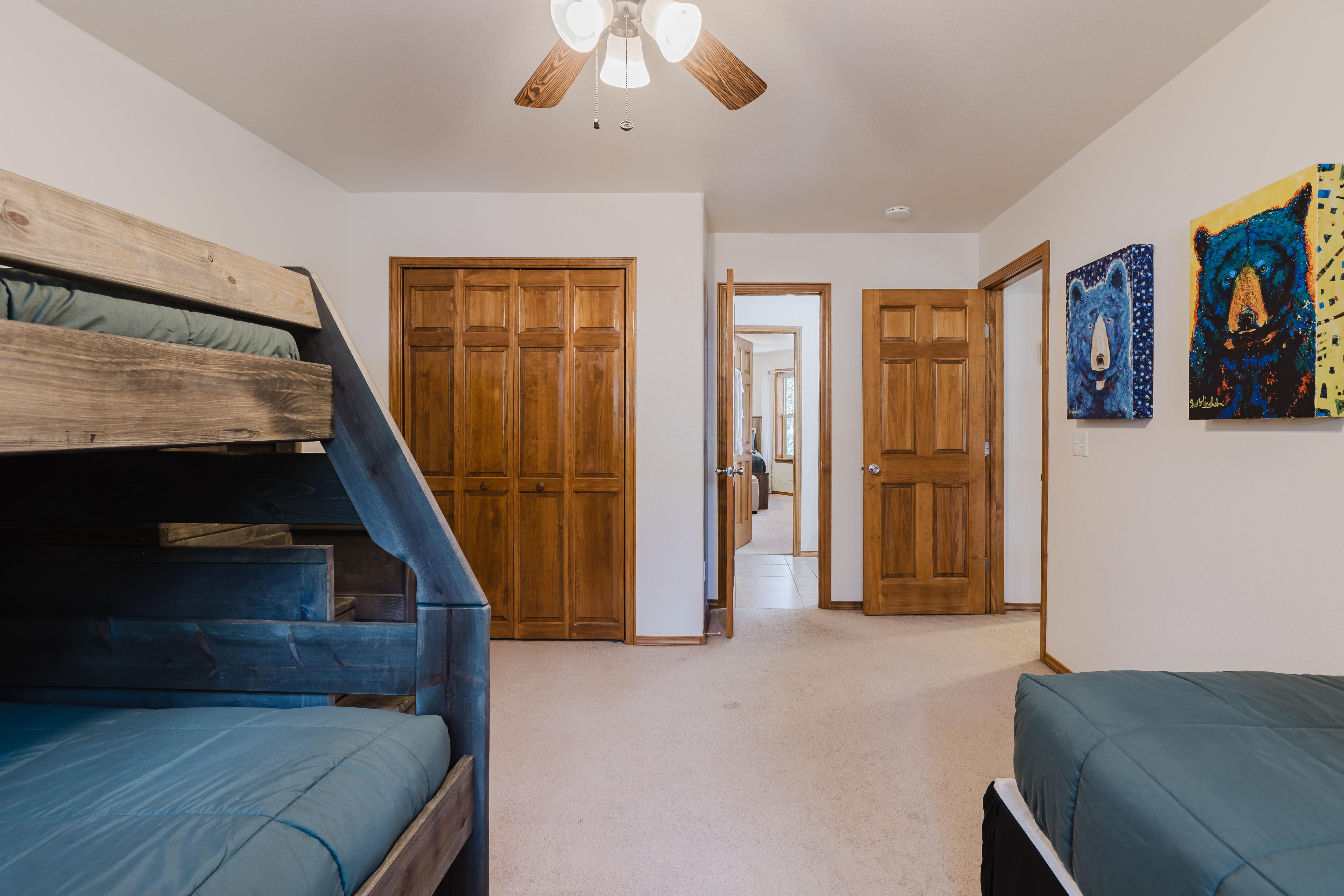 Third bedroom on the upper level with a twin bunk bed and an additional twin bed. 