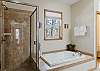 Main bedroom ensuite bathroom with dual vanities, walk-in shower, and soaking tub.