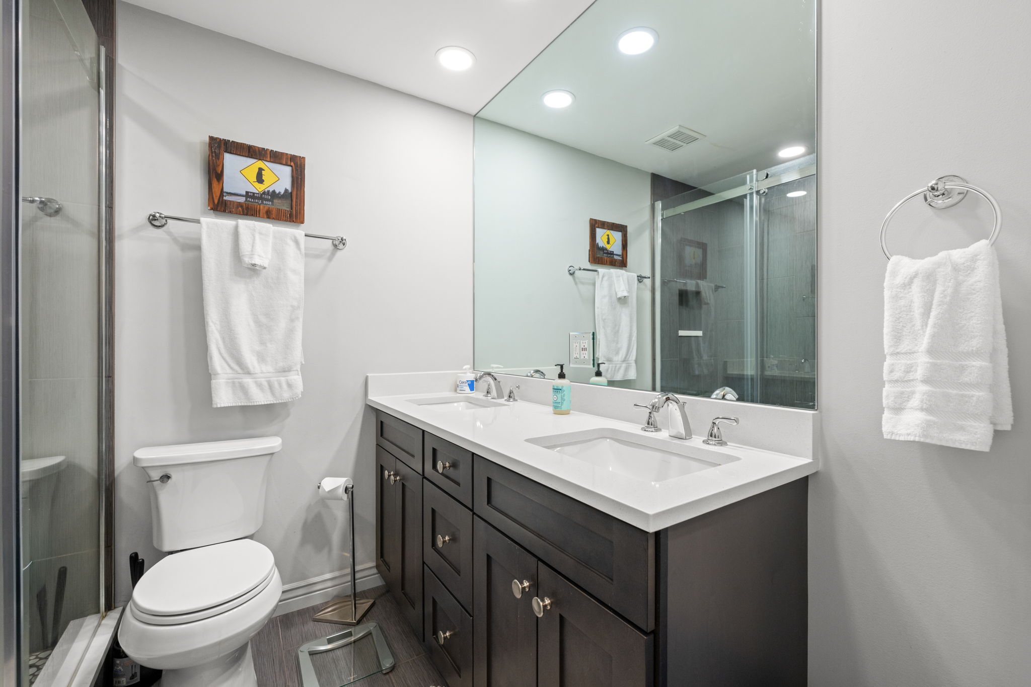 Queen bed, ensuite bathroom with dual sinks and glass shower, private deck access.