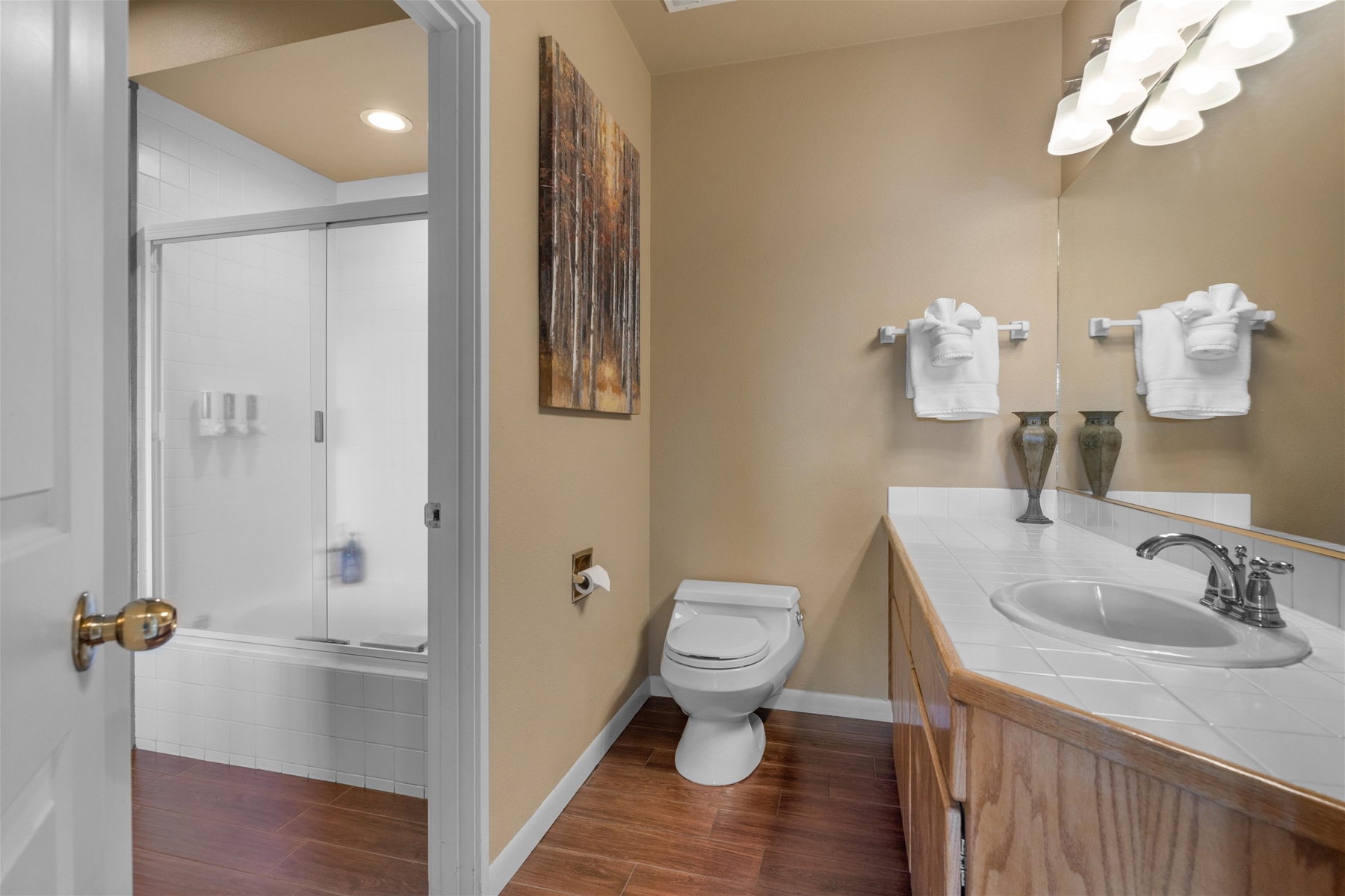 King main bathroom with a combo tub/shower and a stacked laundry setup. 