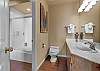 King main bathroom with a combo tub/shower and a stacked laundry setup. 