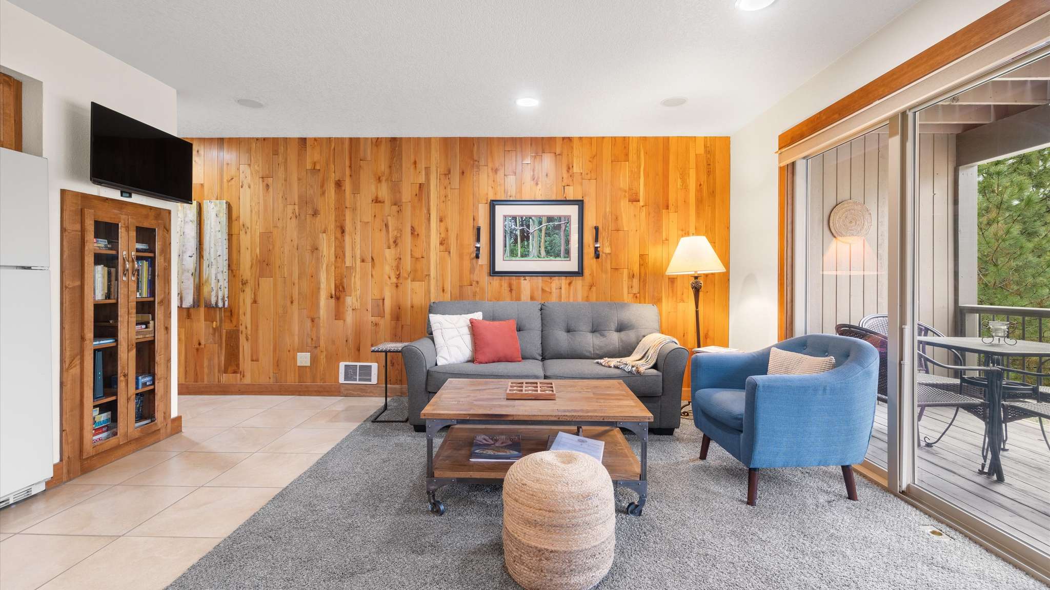 Wood paneling on walls and comfortable living room area with smart TV.