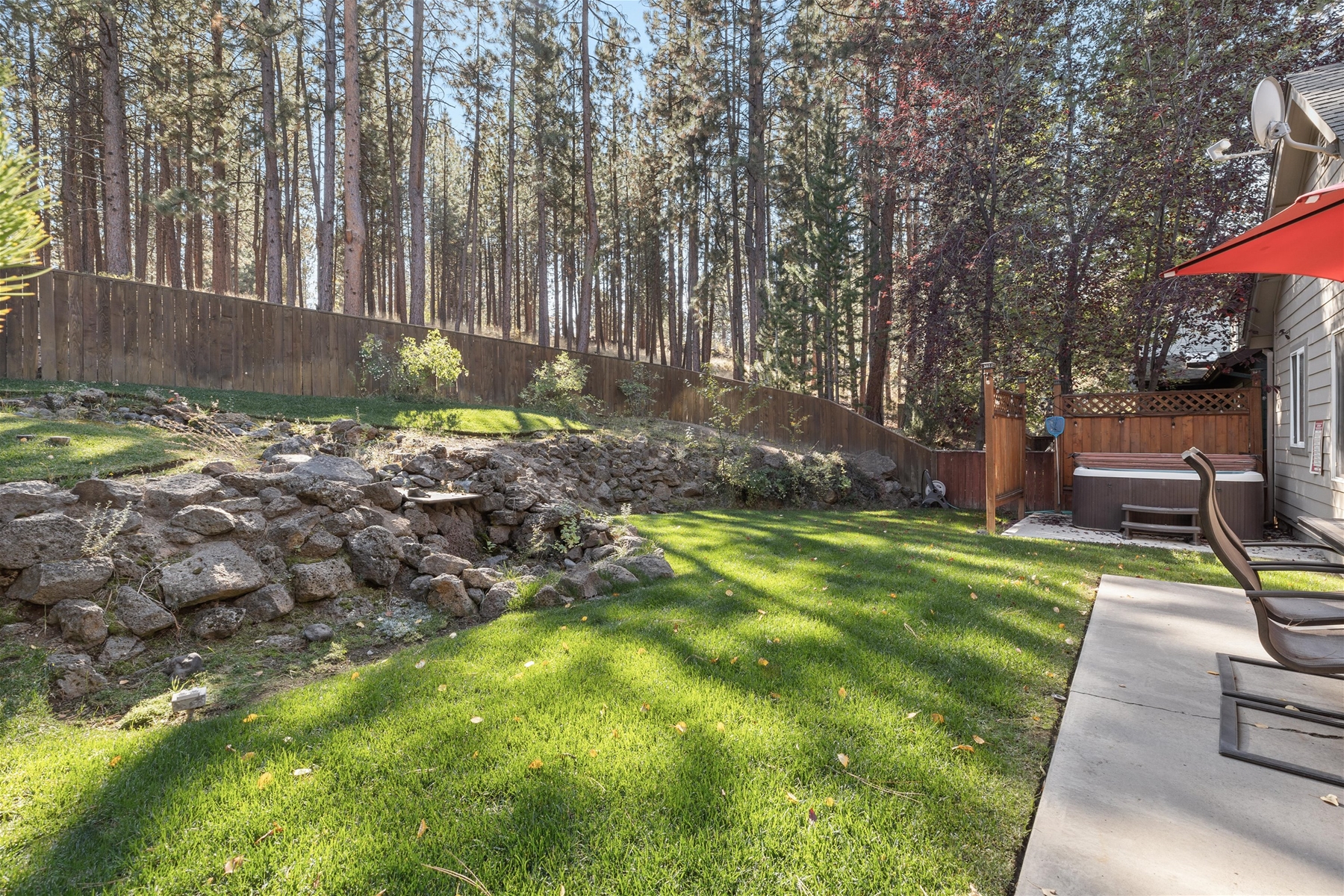 The fenced-in backyard backs up to forest. 