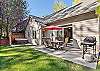 Spacious backyard with a BBQ grill, outdoor dining area, and private hot tub. 