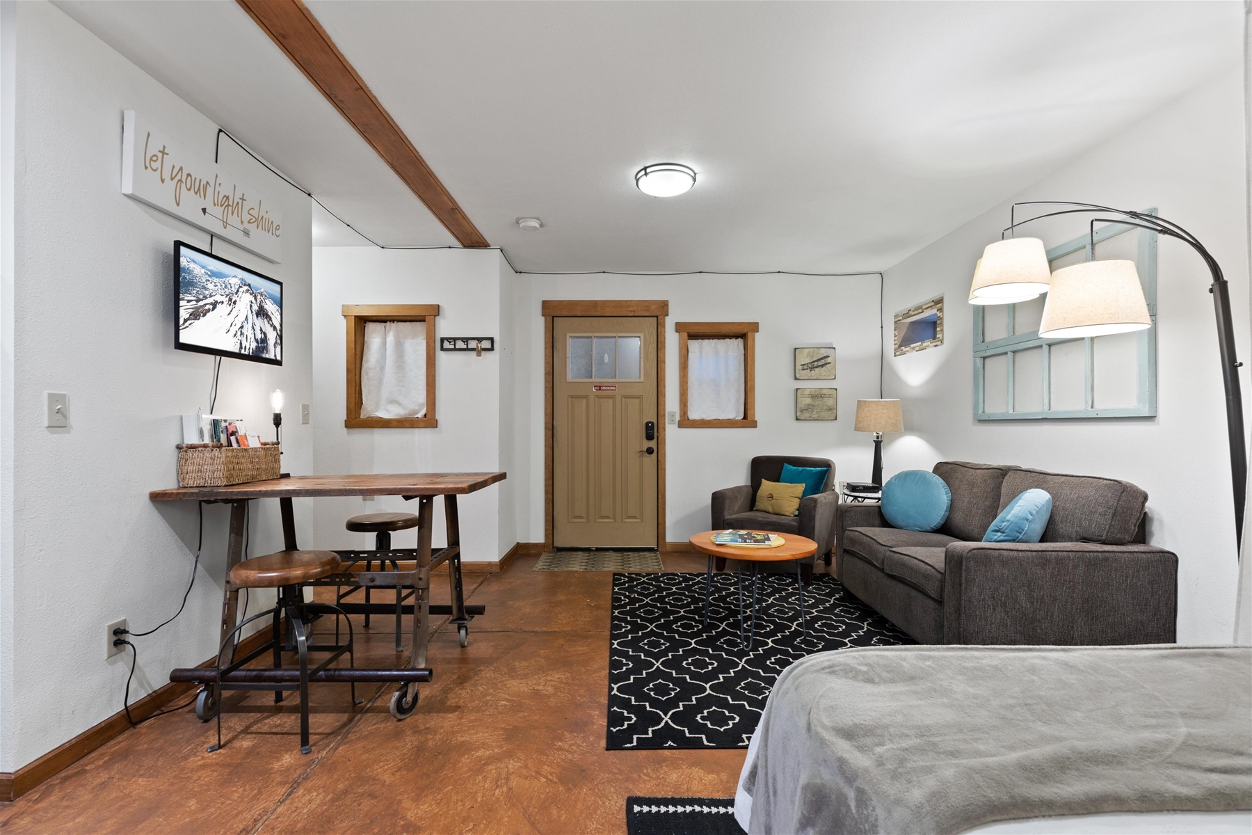 Open studio layout. Living area features a comfortable sofa, smart TV, and dining for 2. 
