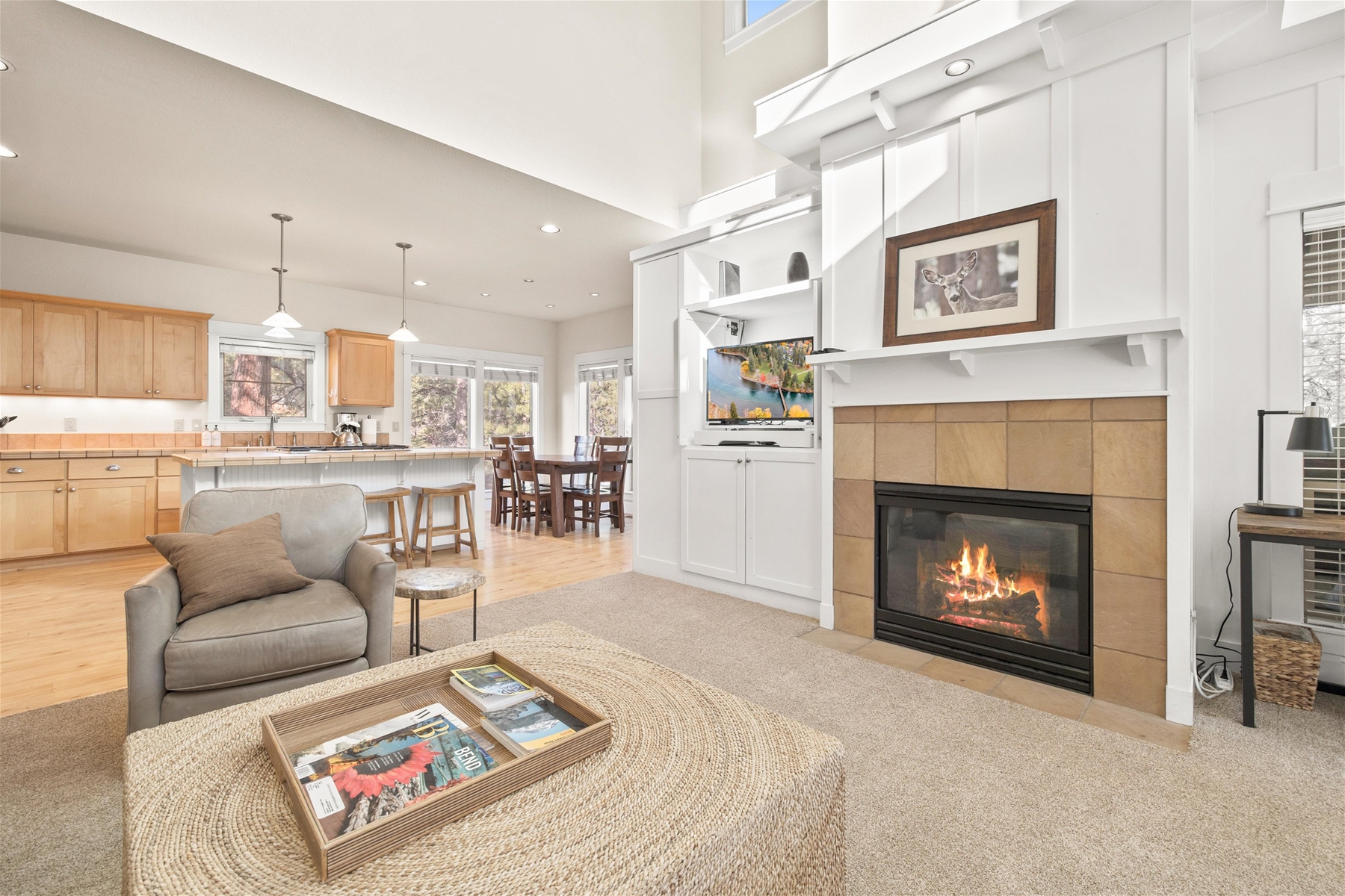 Living room with sectional sofa, fireplace, large smart TV, and a work space.