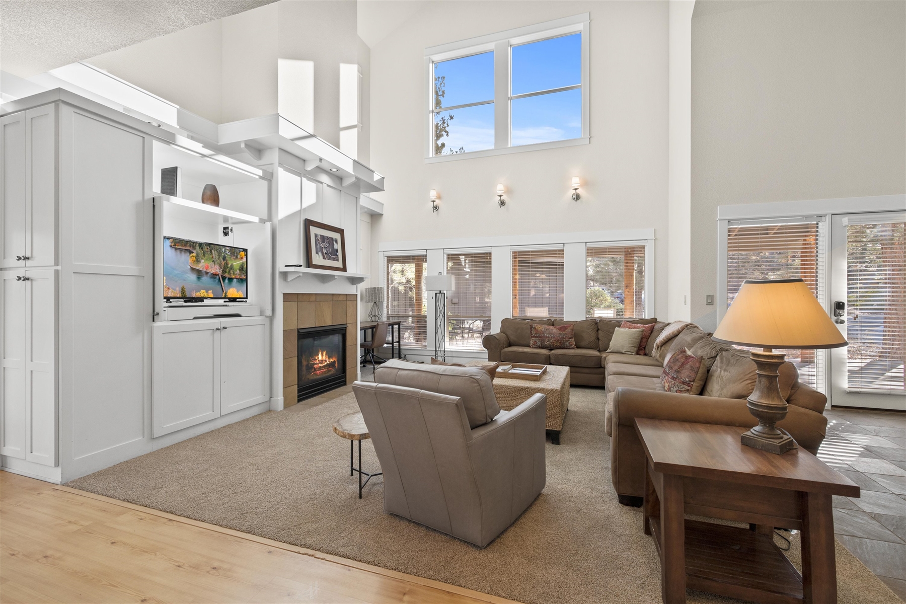 Living room with sectional sofa, fireplace, large smart TV, and a work space.