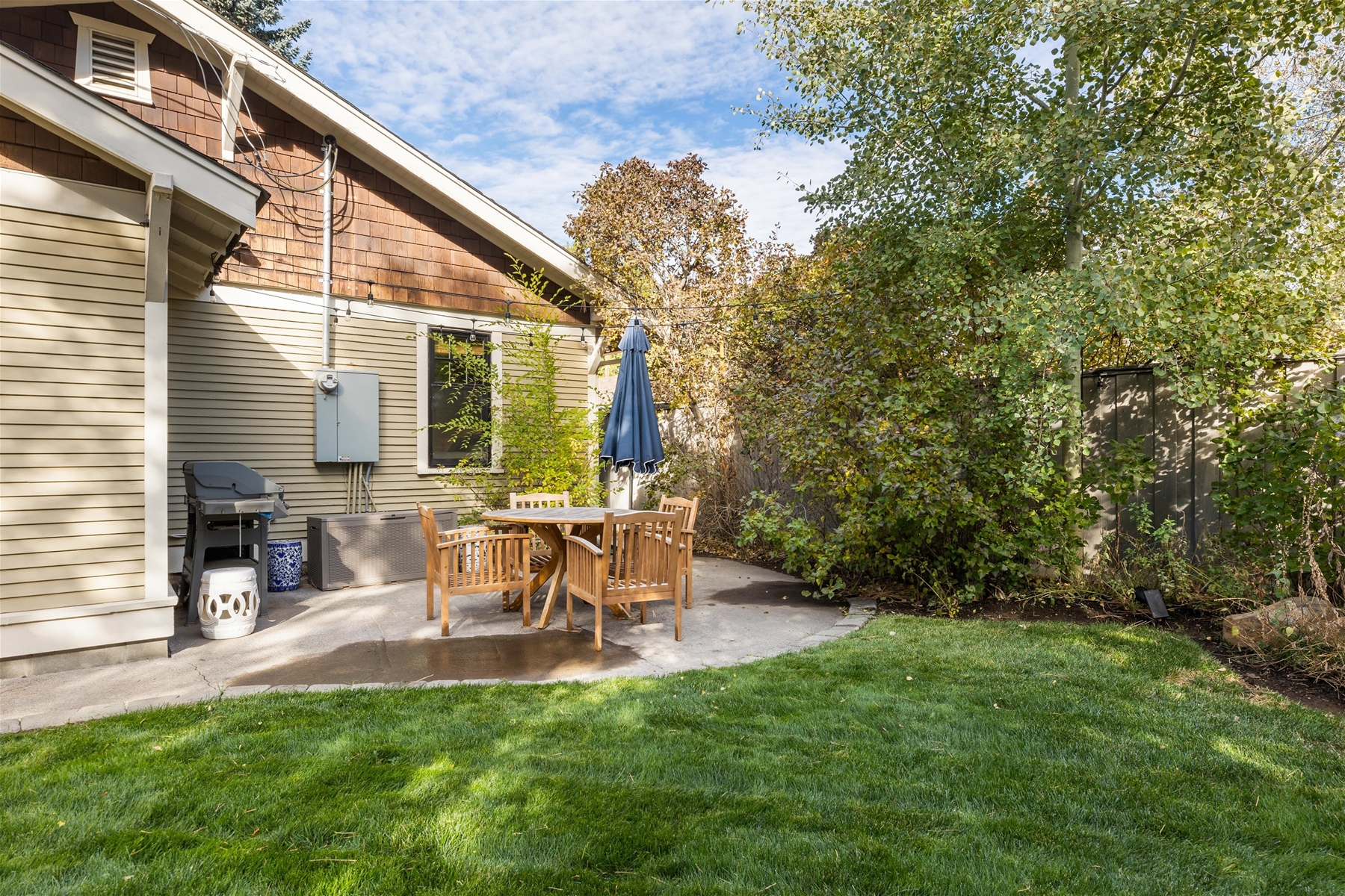 Outdoor patio with a propane BBQ grill and seating for 4. 