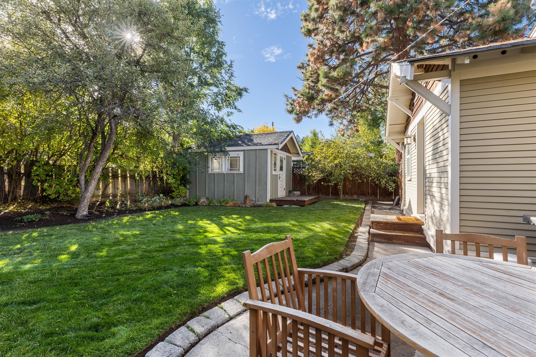 Outdoor patio with a propane BBQ grill and seating for 4. Fully-fenced backyard.