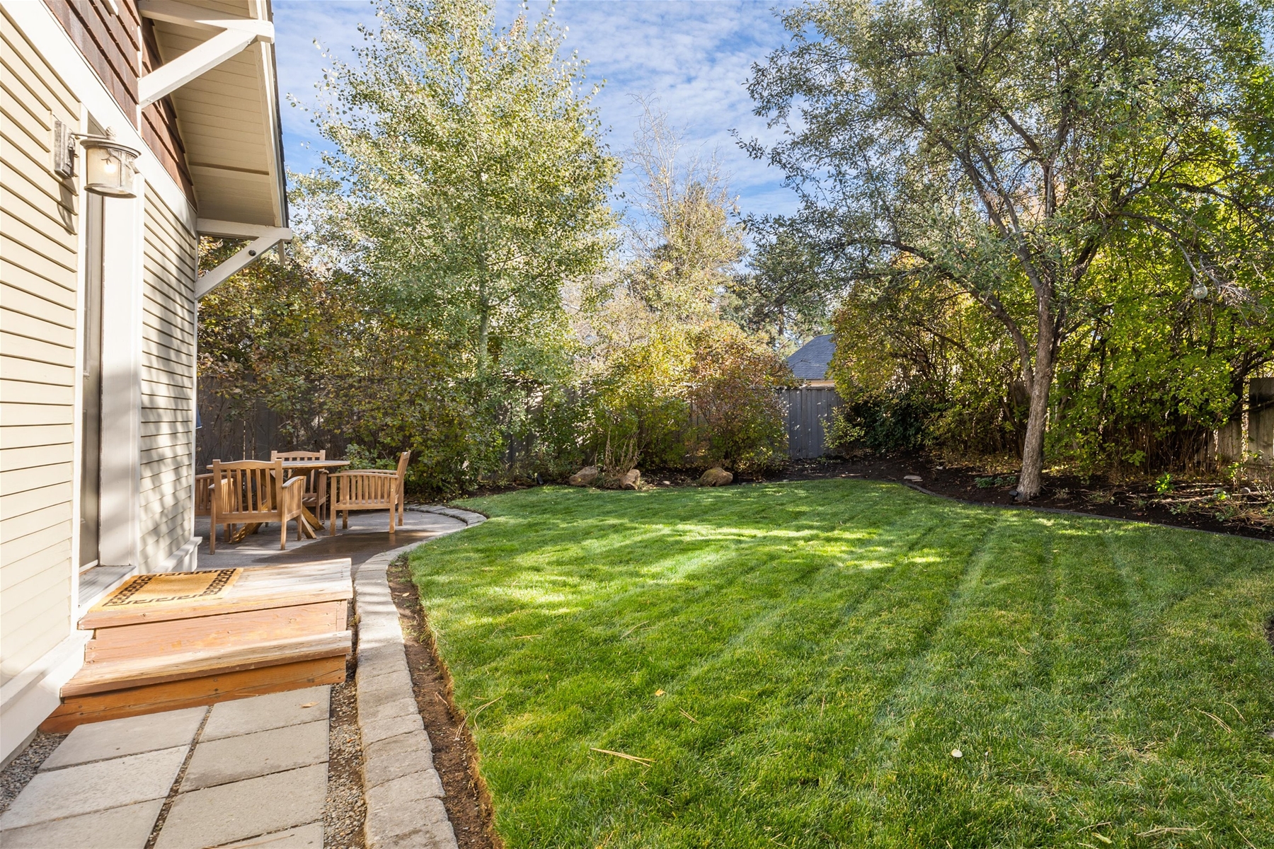Outdoor patio with a propane BBQ grill and seating for 4. Fully-fenced backyard.
