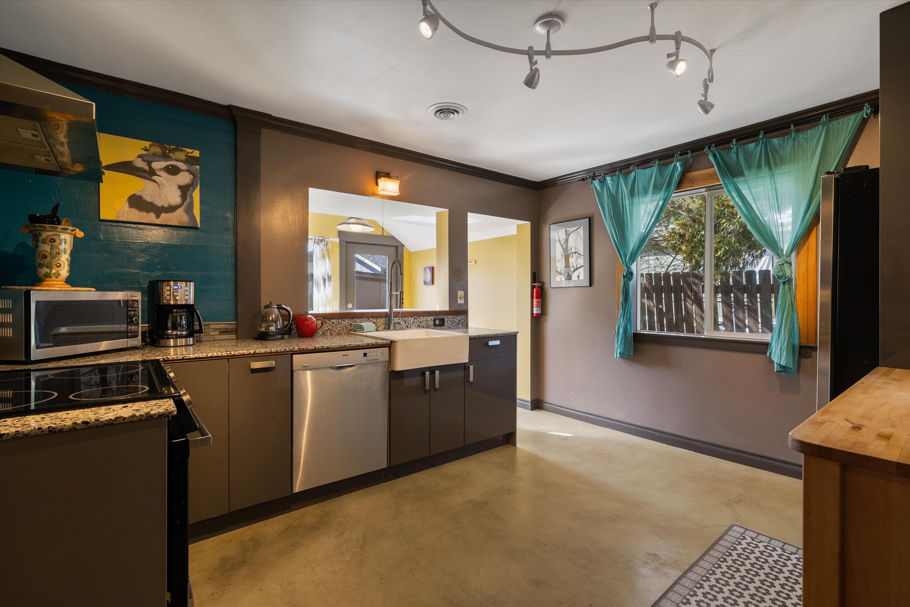 Fully equipped kitchen with granite slab counters and stainless steel appliances.