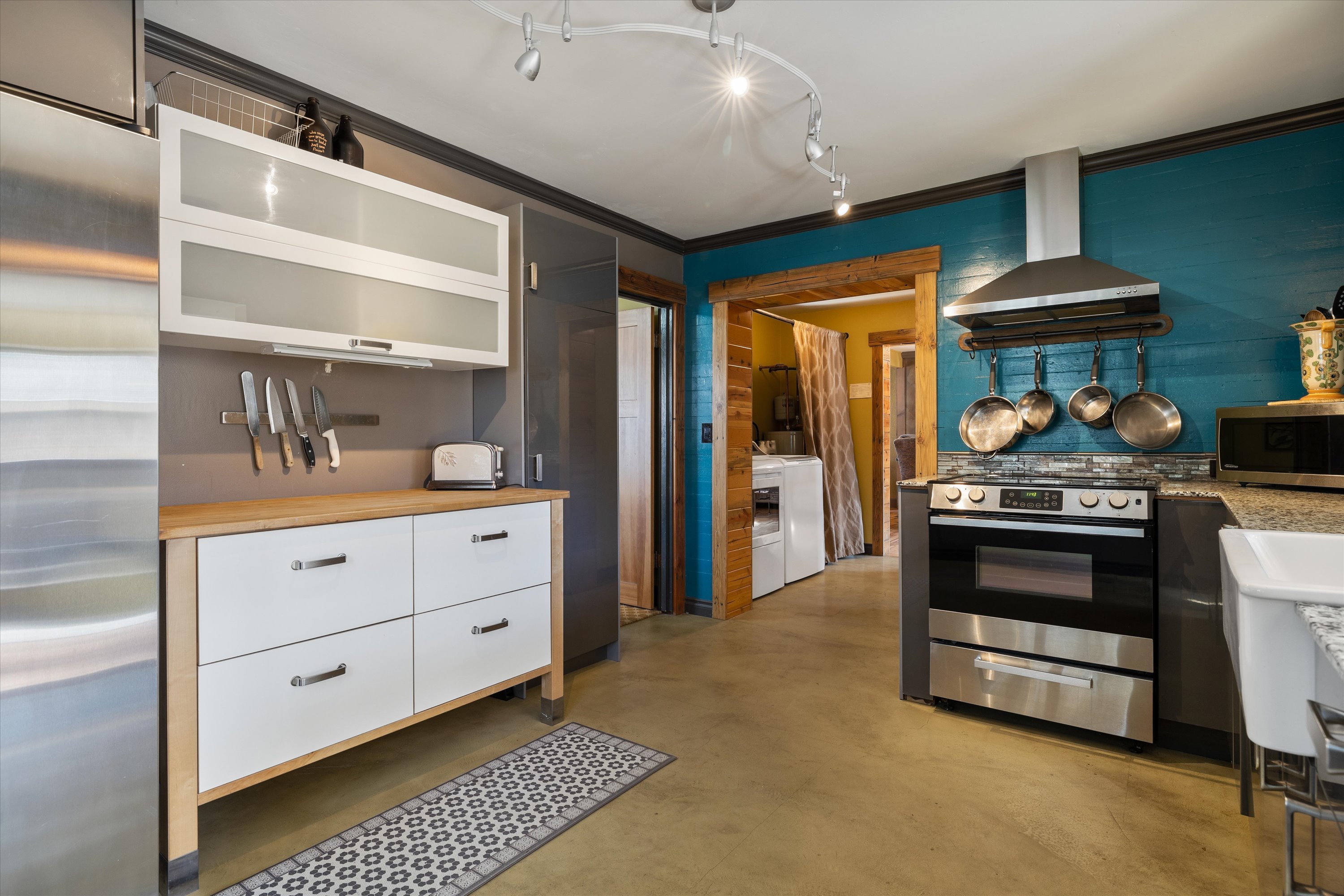 Fully equipped kitchen with granite slab counters and stainless steel appliances.