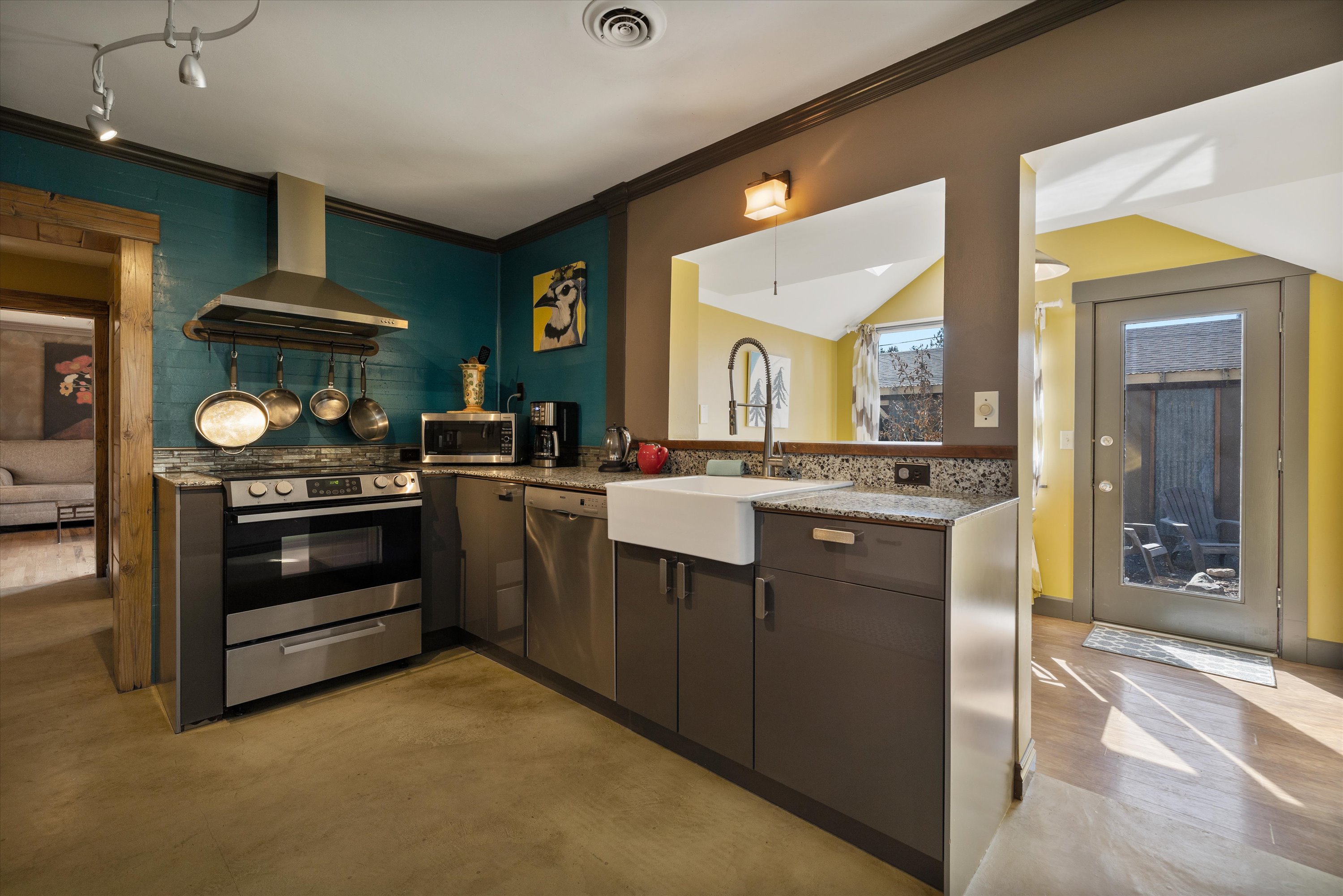 Fully equipped kitchen with granite slab counters and stainless steel appliances.