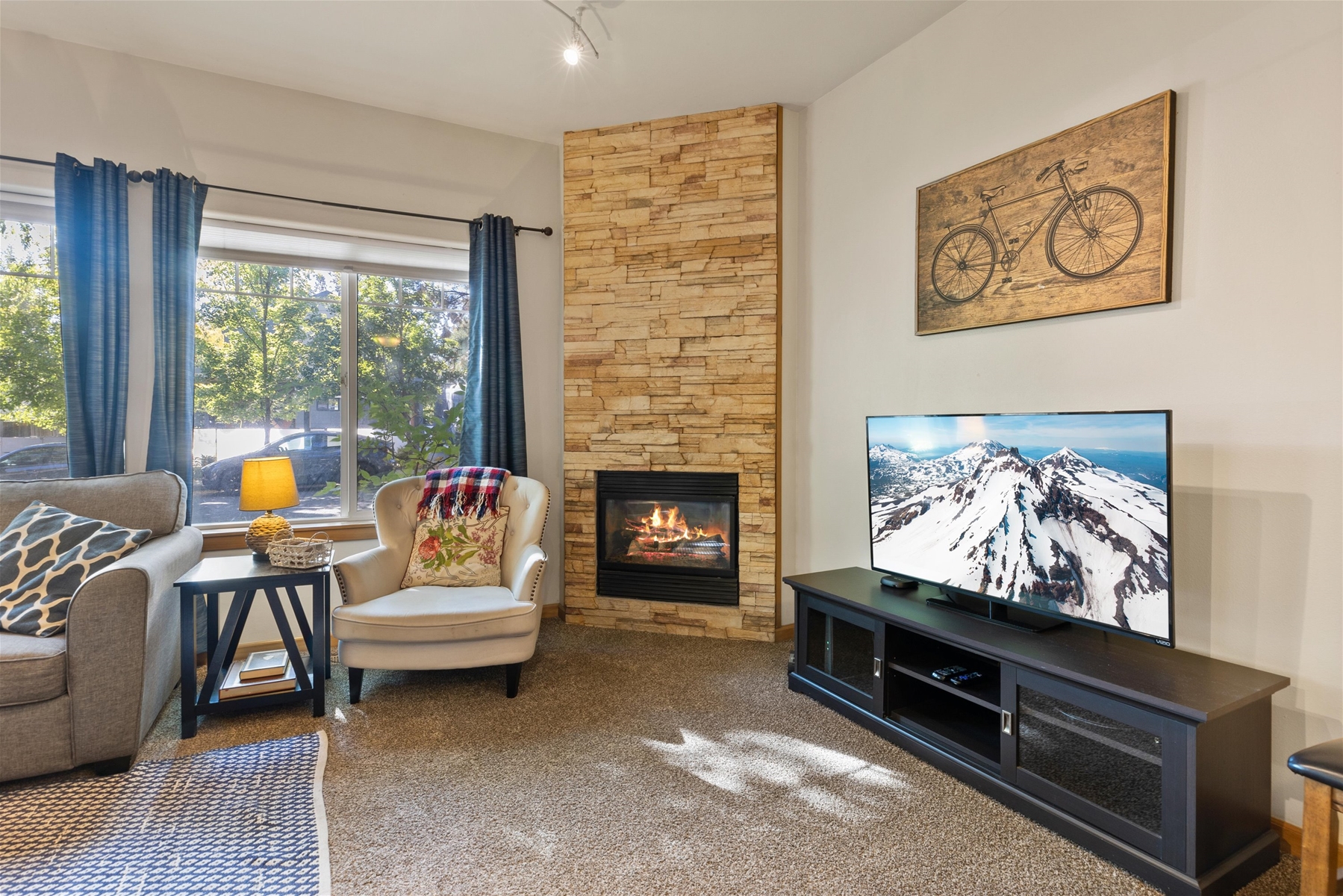Cozy up in style- this living room includes a natural gas fireplace, a smart TV, and an X-Box with games. 