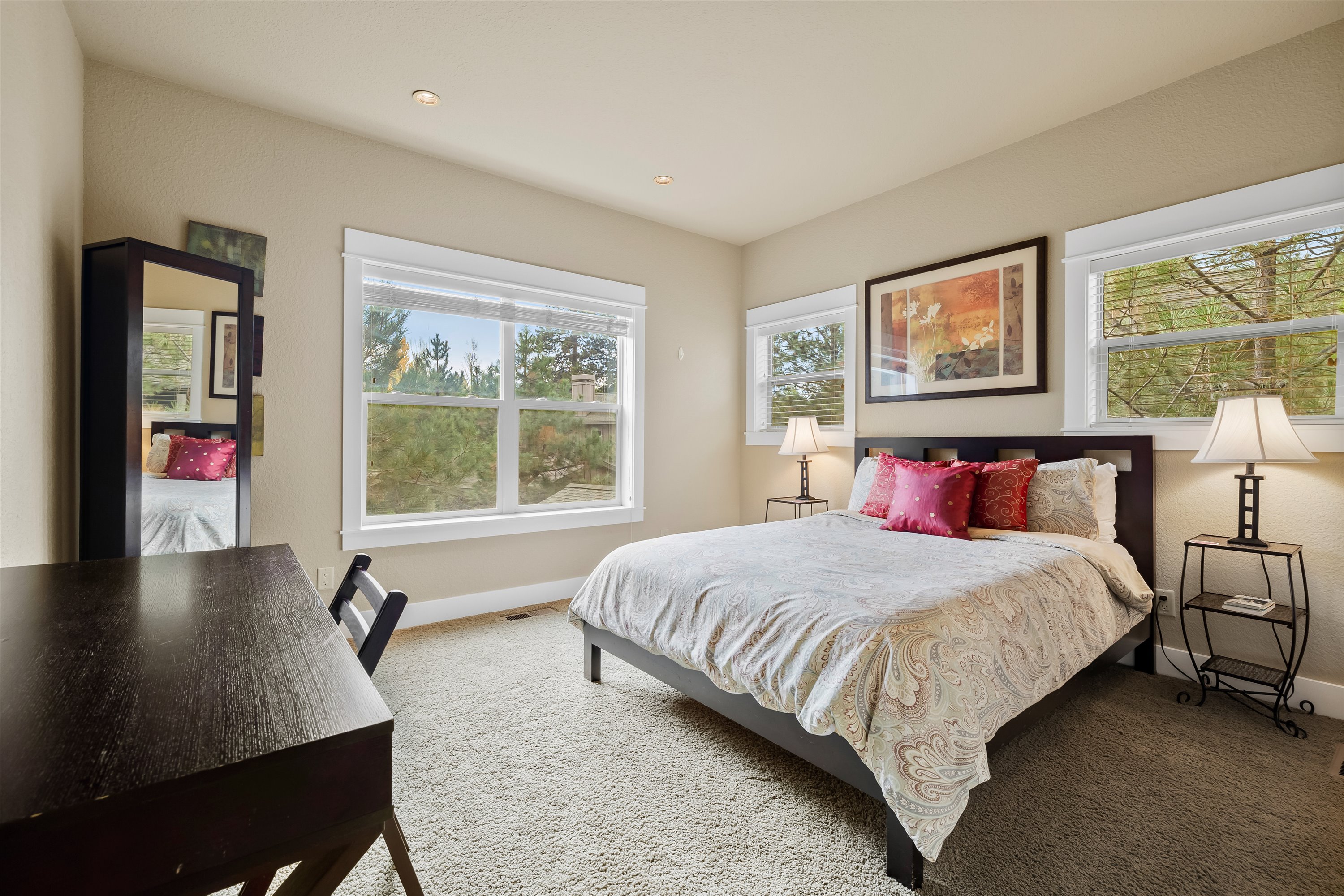 Queen guest suite with large window, desk for remote work, and jack-and-jill bath access.