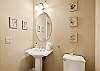 Powder room with pedestal sink and oval mirror. 