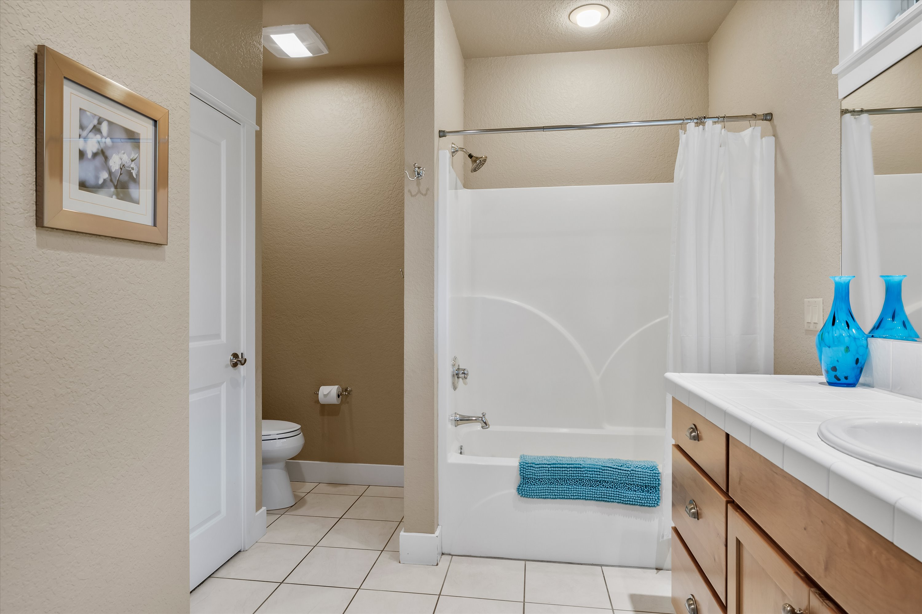 Guest bathroom with tub/shower combo and tile floors.