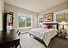 Queen guest suite with large window, desk for remote work, and jack-and-jill bath access.