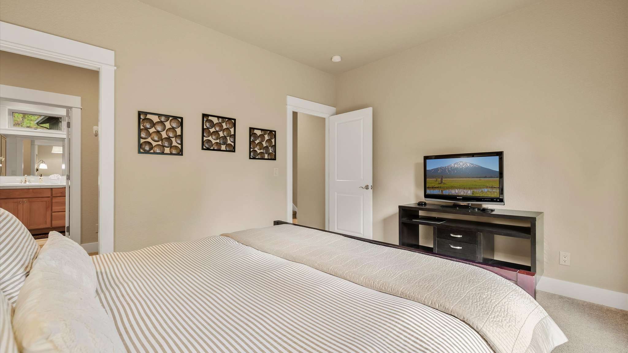 King main suite with flat screen TV, walk-in closet, and private deck access.