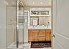 Private en-suite bathroom with glass shower and wood vanity.
