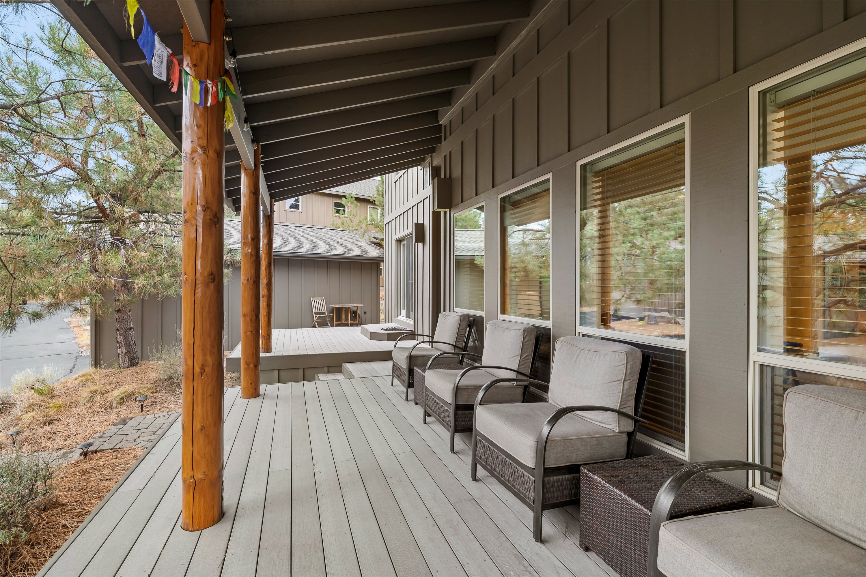 Covered outdoor deck with porch seating and porch swing — Rafters Court, River Wild, Bend OR.