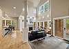 Sunlit living room with fireplace, vaulted ceilings, and wrap-around deck access.