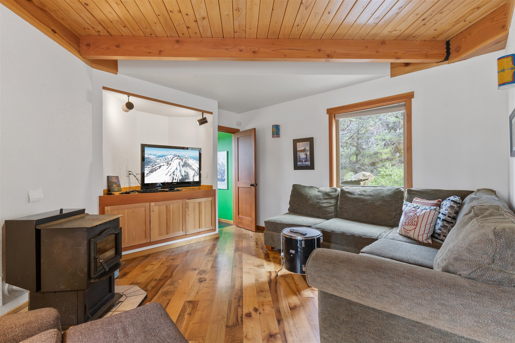 Main living room area with pellet stove and smart TV. 