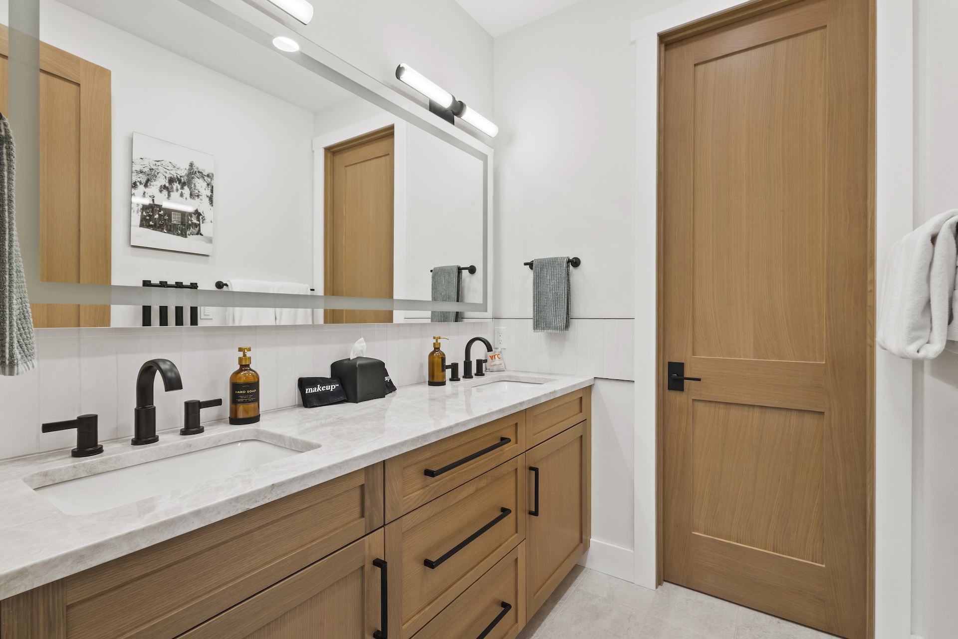 Our shared bathroom features dual vanities, with a separate door leading to a private area with the shower and toilet — offering extra privacy for multiple guests getting ready at once.