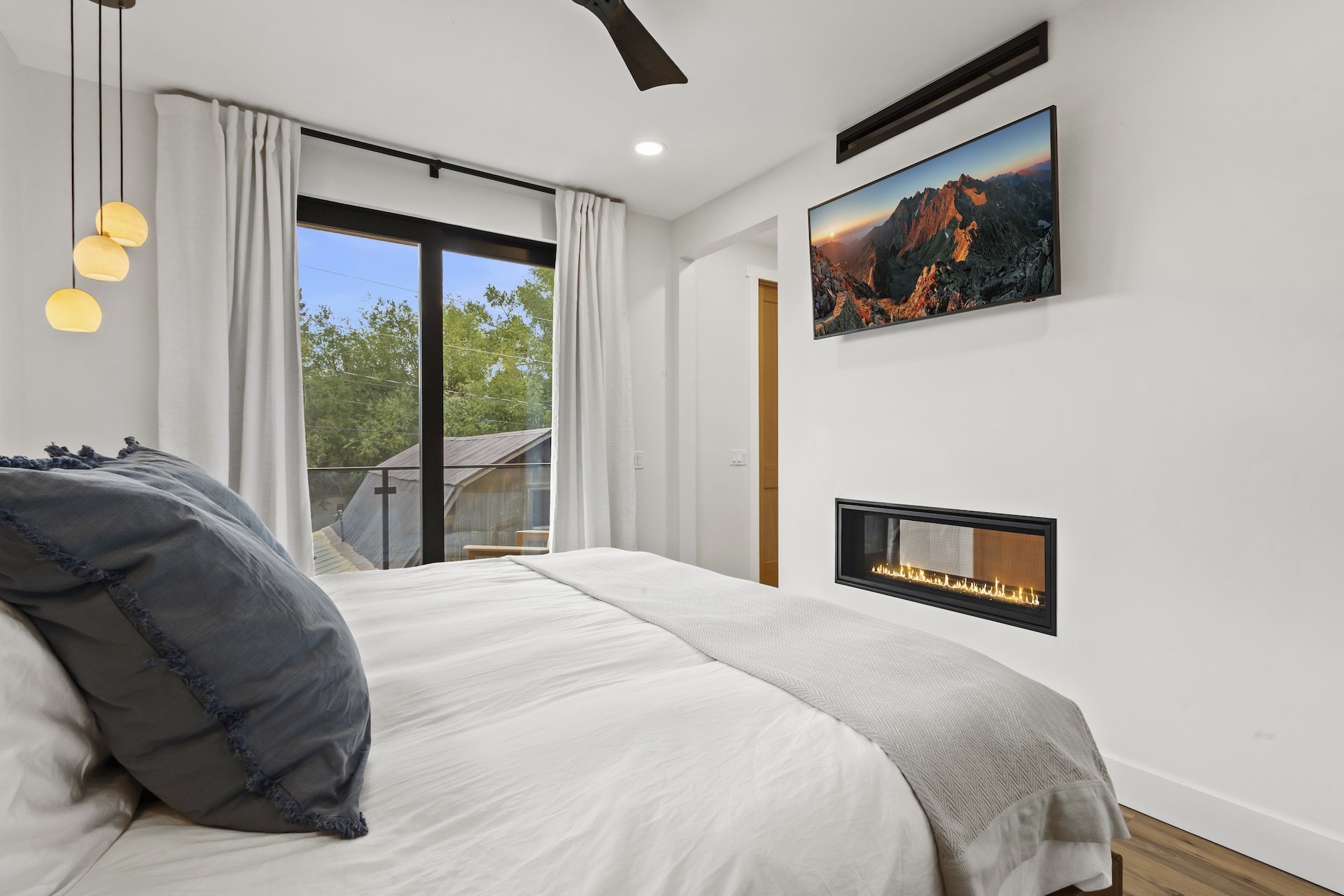 Our primary bedroom features a king bed, pass-through gas fireplace, Smart TV, private balcony, and ensuite bathroom.