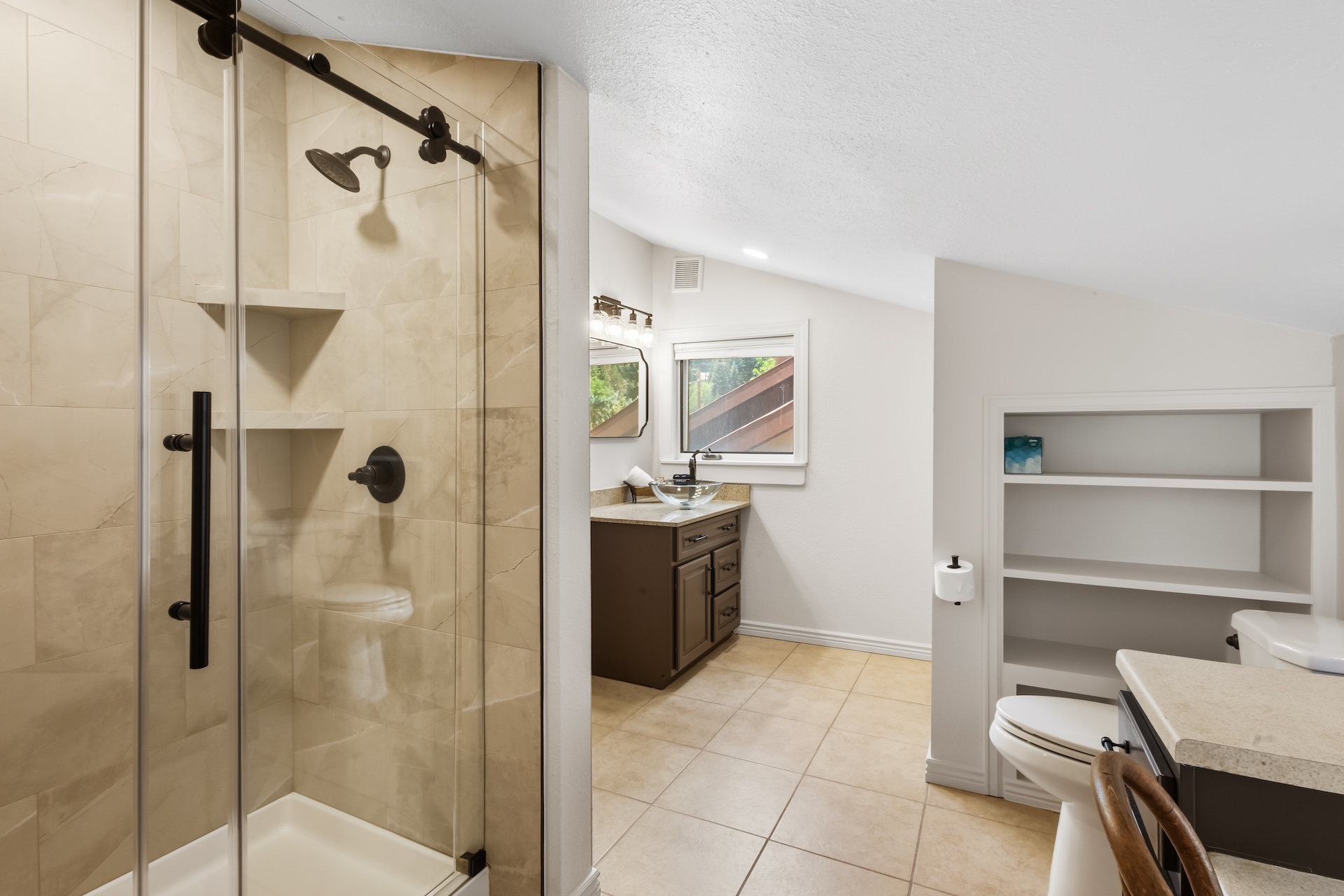 Primary ensuite bathroom featuring a sleek walk-in shower and vanity.