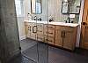 Full bathroom featuring two sinks and a sleek walk-in shower.