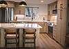 Beautifully designed kitchen and living area with breakfast bar seating for 3 people and dining seating for 4. 