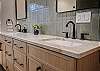 Full bathroom featuring two sinks and a sleek walk-in shower.