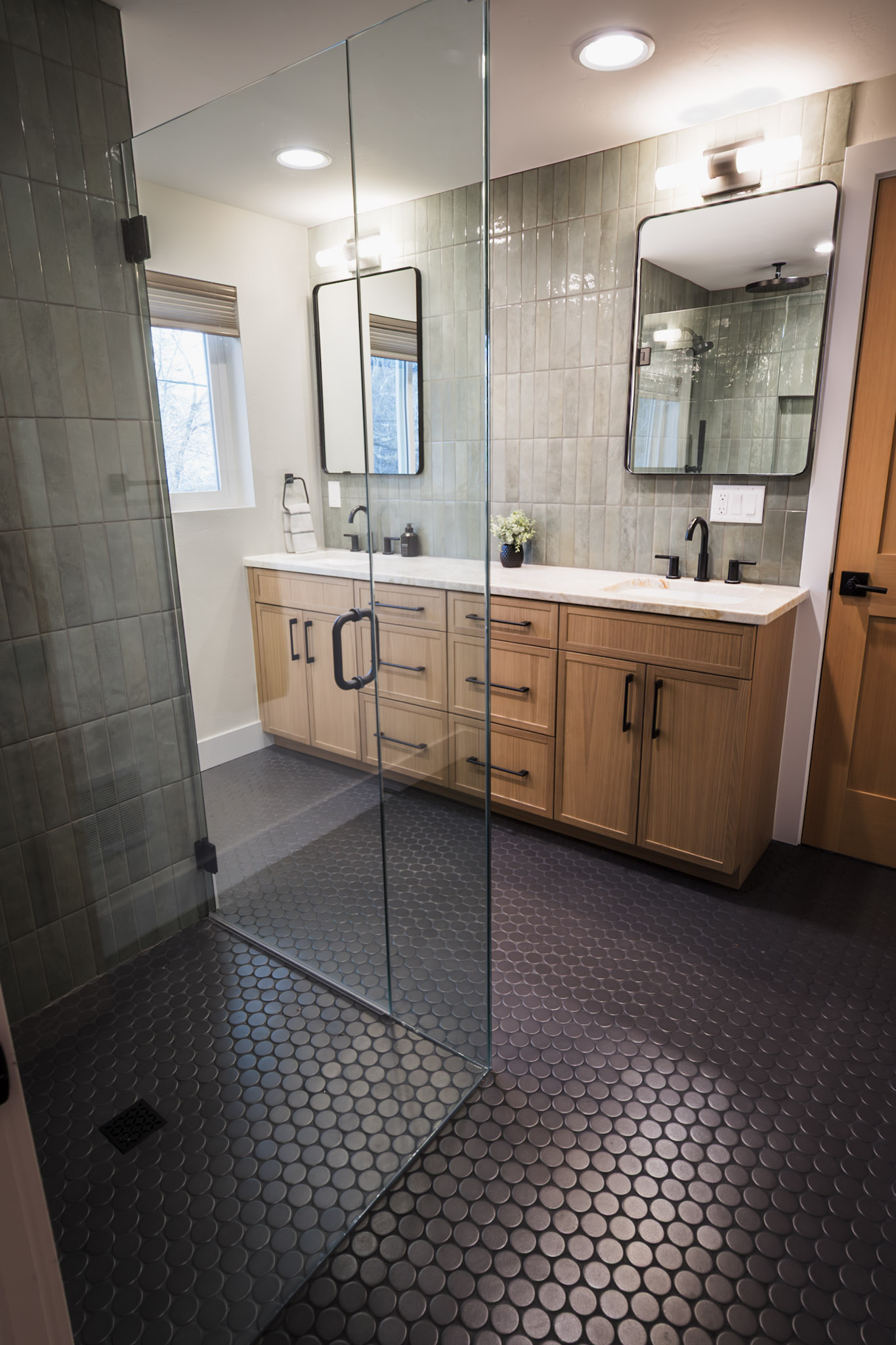 Full bathroom featuring two sinks and a sleek walk-in shower.