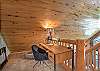 The loft queen bedroom offers a peaceful retreat, complete with a desk and chair.